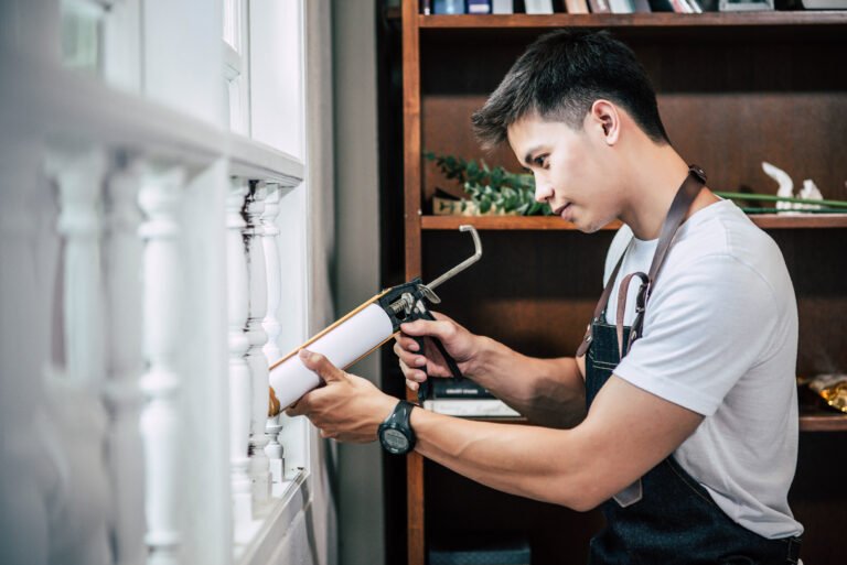 The carpenter holds the glue and attaches to the window